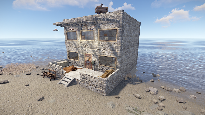Raidable Base am Strand mit Wasser im Hintergrund